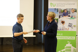 50_SchuelerUni_7813 Feierliche Übergabe erworbener Zertifikate zwischen der Prorektorin Studium Frau Prof. Dr. Wiebke Möhring und einem Teilnehmer während der Eröffnungsveranstaltung der SchülerUni für das Wintersemester 2024/2025.