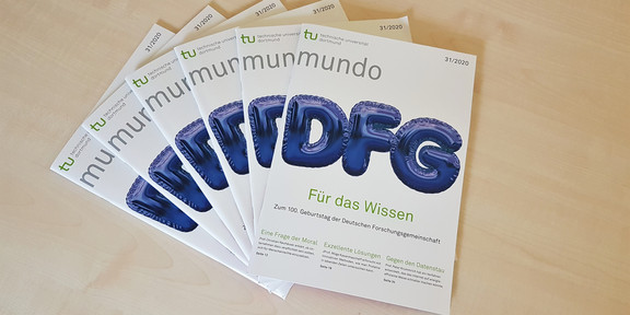 mundo Sechs Ausgaben der mundo 31 liegen aufgefächert auf einem Holztisch.