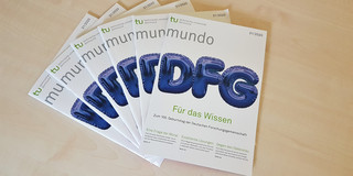 mundo Sechs Ausgaben der mundo 31 liegen aufgefächert auf einem Holztisch.