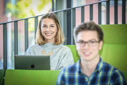 März Zwei Studierende sitzen in einem Hörsaal.