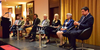 Several people sit next to each other on a stage.