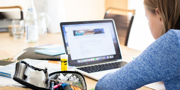 Mädchen am Laptop Mädchen vor Laptop mit Schulmaterial