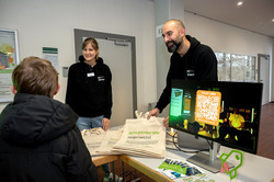 Das Bild zeigt Mitarbeitende des Centrums für Entrepreneurship & Transfer sowie einen Ecktisch. Auf diesem liegen unter anderem Flyer und Jutebeutel.