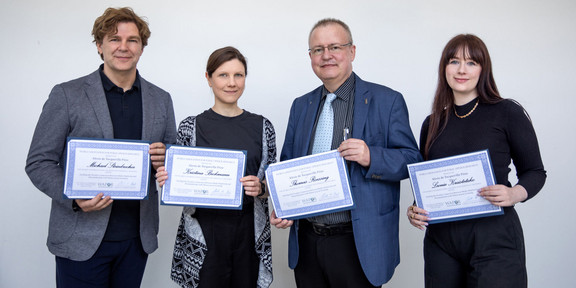 Gruppenfoto: Vier Forschende stehen nebeneinander und halten jeweils eine Urkunde in den Händen.