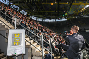 Christoph Edeler wirft den schwarz-gelben Ball mit Autogrammen in die Menge der Tribünenbesucher.