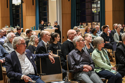 Das Bild zeigt einen großen Saal mit sitzenden Menschen in Anzügen beim Gambrinus-Forum.