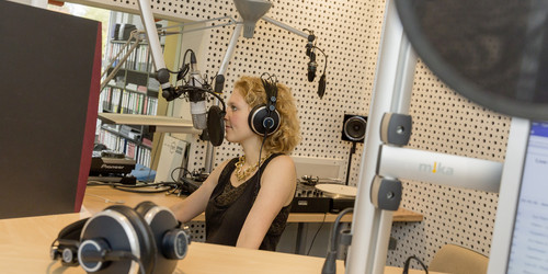Studentin am Mikrofon bei Aufnahme bei Eldoradio im Studio