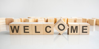 Schriftzug "Welcome" aus Buchstabenblöcken zusammengesetzt