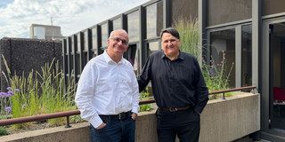 Foto: TU-Rektor Manfred Bayer und Martin Paul, Rektor der Ruhr-Universität Bochum, stehen auf einer begrünten Terrasse auf dem Campus der Ruhr-Universität Bochum.