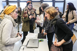 Zwei Frauen stehen sich an einem Tisch gegenüber und unterhalten sich