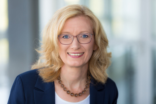 Melle Frau Melle lächelt in die Kamera.