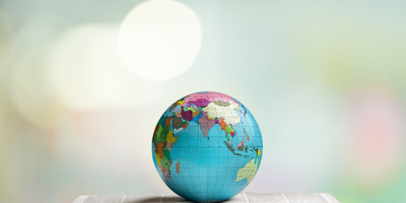 globe lies on an open book A globe lies on an open thick book.