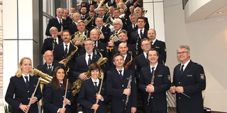Die Mitglieder des Landespolizeiorchester NRW stehen mit ihren Instrumenten auf einer Treppe.