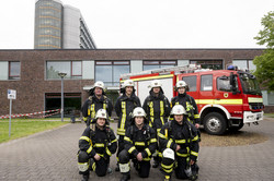 sechs Feuerwehrleute lächeln für ein Gruppenfoto