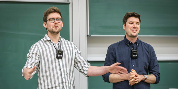 Zwei Personen stehen in einem Hörsaal