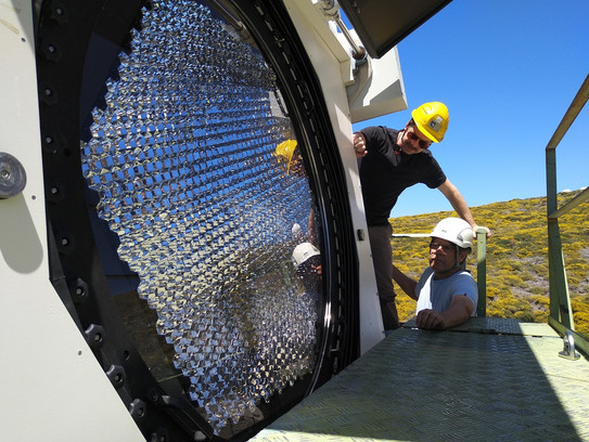 People wearing a helmet on the MAGIC telescope.