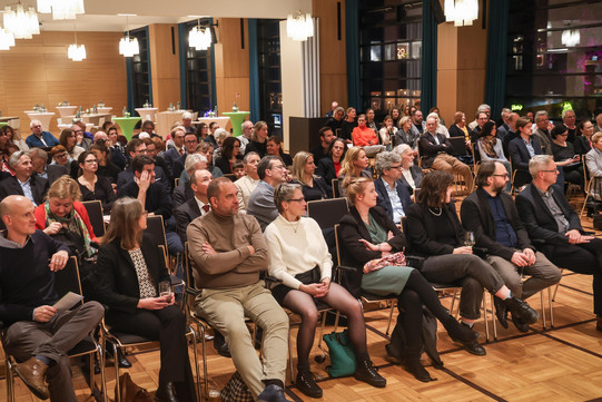 Foto: Gäste sitzen im Saal.