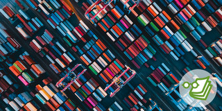 Foto: Eine Luftaufnahme zeigt bunte Containerreihen und Kräne.