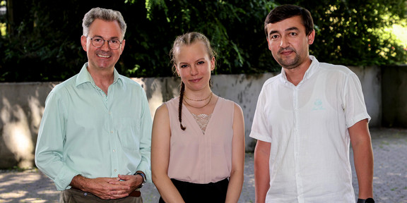 Ein Gruppenfoto von zwei Männern und einer Frau.
