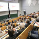 Voller Hörsaal mit Menschen aus allen Altersklassen, die einem Vortrag zur Energiewende zuhören.