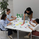 Das Foto zeigt fünf Studierende an einem Tisch sitzen, die gemeinsam einer Gruppenarbeit nachgehen.
