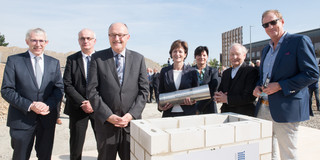 Grundsteinlegung für neuen Forschungsbau CALEDO Sieben Personen stehen in einer Reihe und versenken eine Zeitkapsel für den neuen Forschungsbau CALEDO an der TU Dortmund