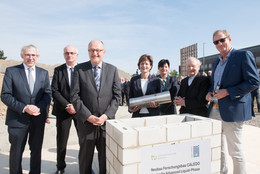 September Sieben Personen stehen in einer Reihe und versenken eine Zeitkapsel für den neuen Forschungsbau CALEDO an der TU Dortmund
