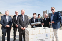 September Sieben Personen stehen in einer Reihe und versenken eine Zeitkapsel für den neuen Forschungsbau CALEDO an der TU Dortmund