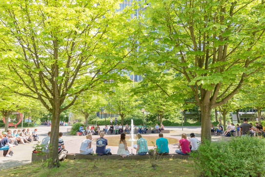 Studenten und Studentinnen sitzen am Martin-Schmeißer-Platz