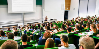 Studierende sitzen während einer Vorlesung in einem Hörsaal.