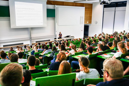 April Studierende sitzen während einer Vorlesung in einem Hörsaal.