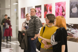 Zwei Menschen unterhalten sich in einem Ausstellungsraum mit Fotografien