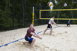 Mehrere Personen spielen Beachvolleyball.