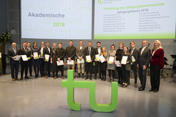 Akademische Jahresfeier_9 Gruppenfoto, im Vordergrund steht ein grünes TU-Logo