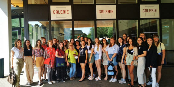 A group of women is standing in front of a building.