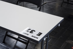 A white table with a note with the inscription "Section E, Seat 37"