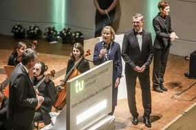 LED wall, on which, among other things, the “Guest and Study House of the TU Dortmund” is displayed on the stage, with several people standing next to it