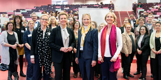 50 Jahre ZSB in NRW mehrere Personen stehen im unteren Teil eines Vorlesungssaals und feiern gemeinsam 50 Jahre Zentrale Studienberatung in NRW