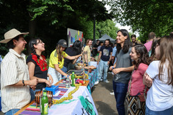 Foto: Mehrere Personen stehen an einem internationalen Stand und unterhalten sich mit den Menschen am Stand.