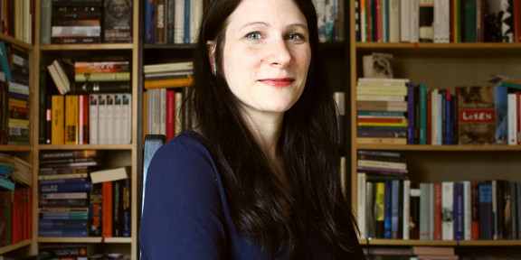 Portrait of Dr. Simone Horstmann in front of a bookshelf.