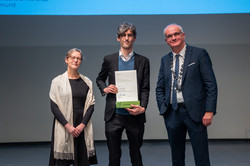 Prof. Manfred Bayer, Rektor der TU Dortmund, und eine Frau überreichen eine Urkunde an eine ausgezeichnete Person.