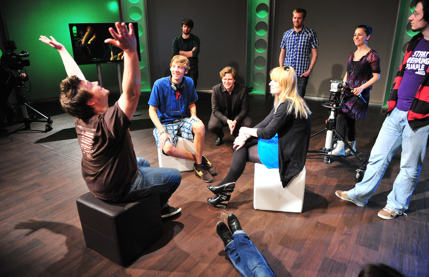Journalistik-Studierende sitzen und stehen im Fernseh-Studio und besprechen sich