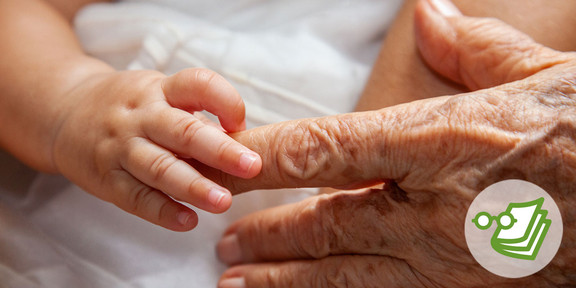 Die Hand eines Babys, die den Finger einer älteren Person hält.