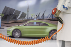 Elektroauto Ein grünes Elektroauto lädt an einer Ladesäule