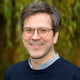 Portraitfoto von Bernd Sommer, im Hintergrund verschwommen eine Trauerweide. 