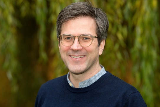 Portraitfoto von Bernd Sommer, im Hintergrund verschwommen eine Trauerweide. 