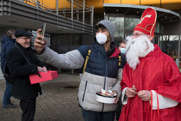 Der Nikolaus macht mit einem Studenten ein Selfie.