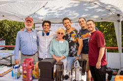 Sechs Personen stehen für ein Gruppenfoto nebeneinander hinter einem Stand.