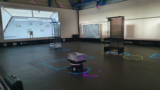 Photo: A hall with a projection displays a test environment for autonomous robots.