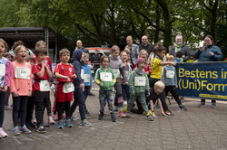 Viele Kinder in Sportkleidung stehen an einer Startlinie für einen Lauf.